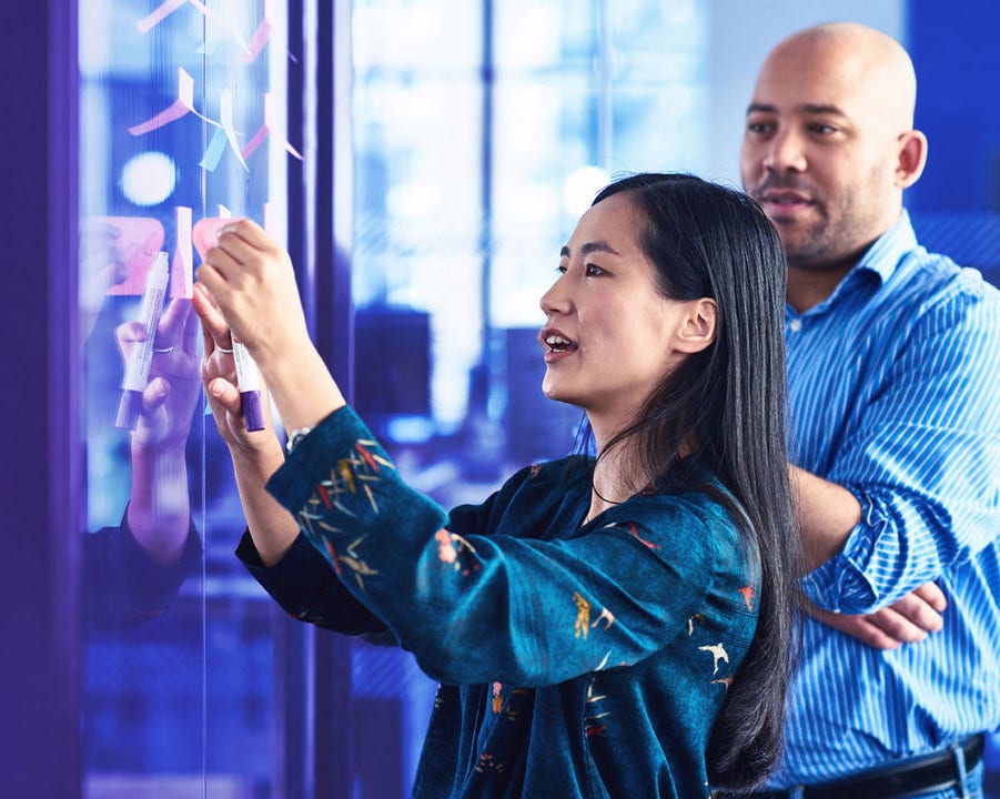 man and woman sticking notes