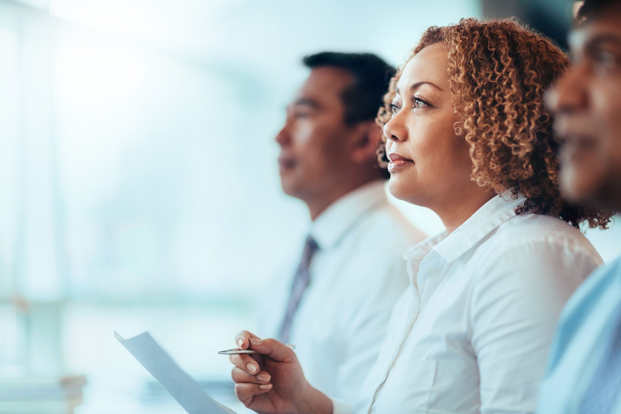 Japanese African-American mature businesswoman student sitting learning listening in education training seminar meeting in business office classroom with multiracial colleagues