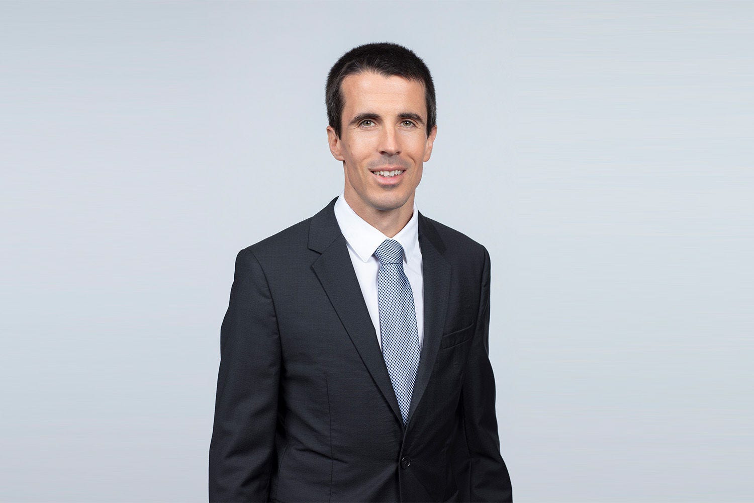 Porträt von Lukas Maukner vor einer hellgrauen Wand