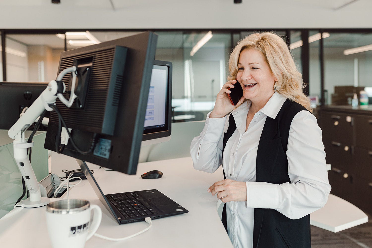 KPMG employee talking on phone by computer