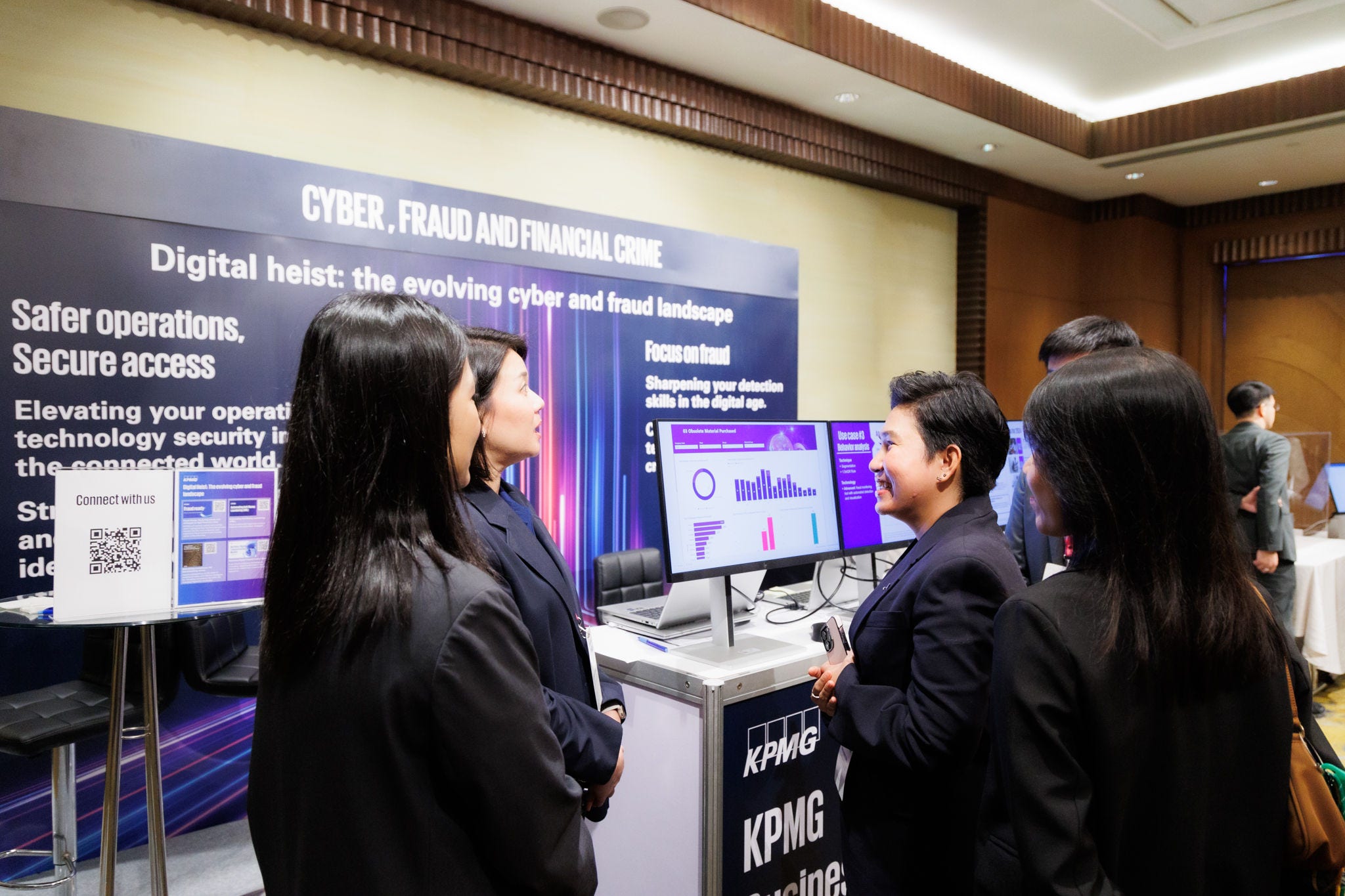 Attendee visiting KPMG cyber crime booth and talking to KPMG cybersecurity specialists