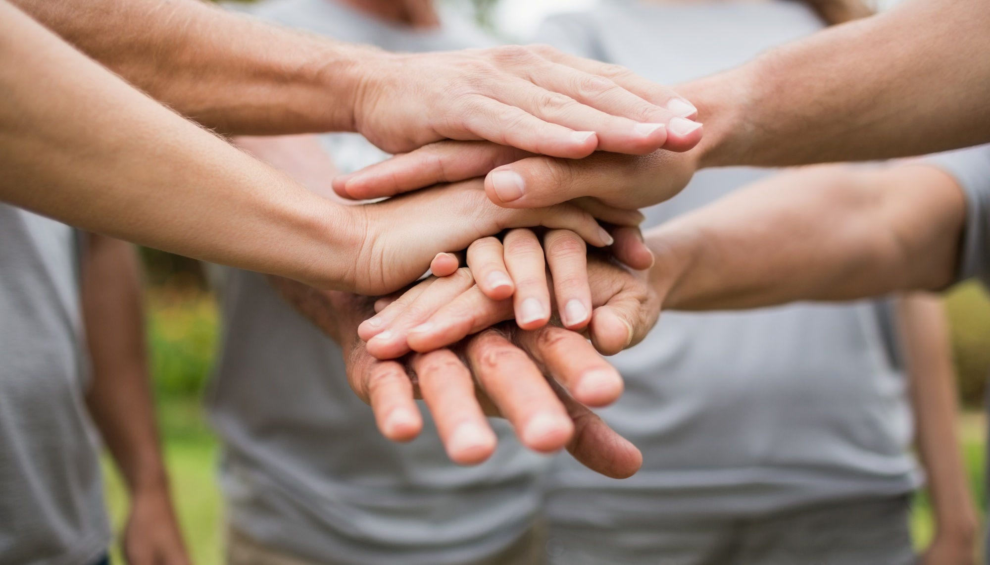 Happy volunteer family putting their hands together