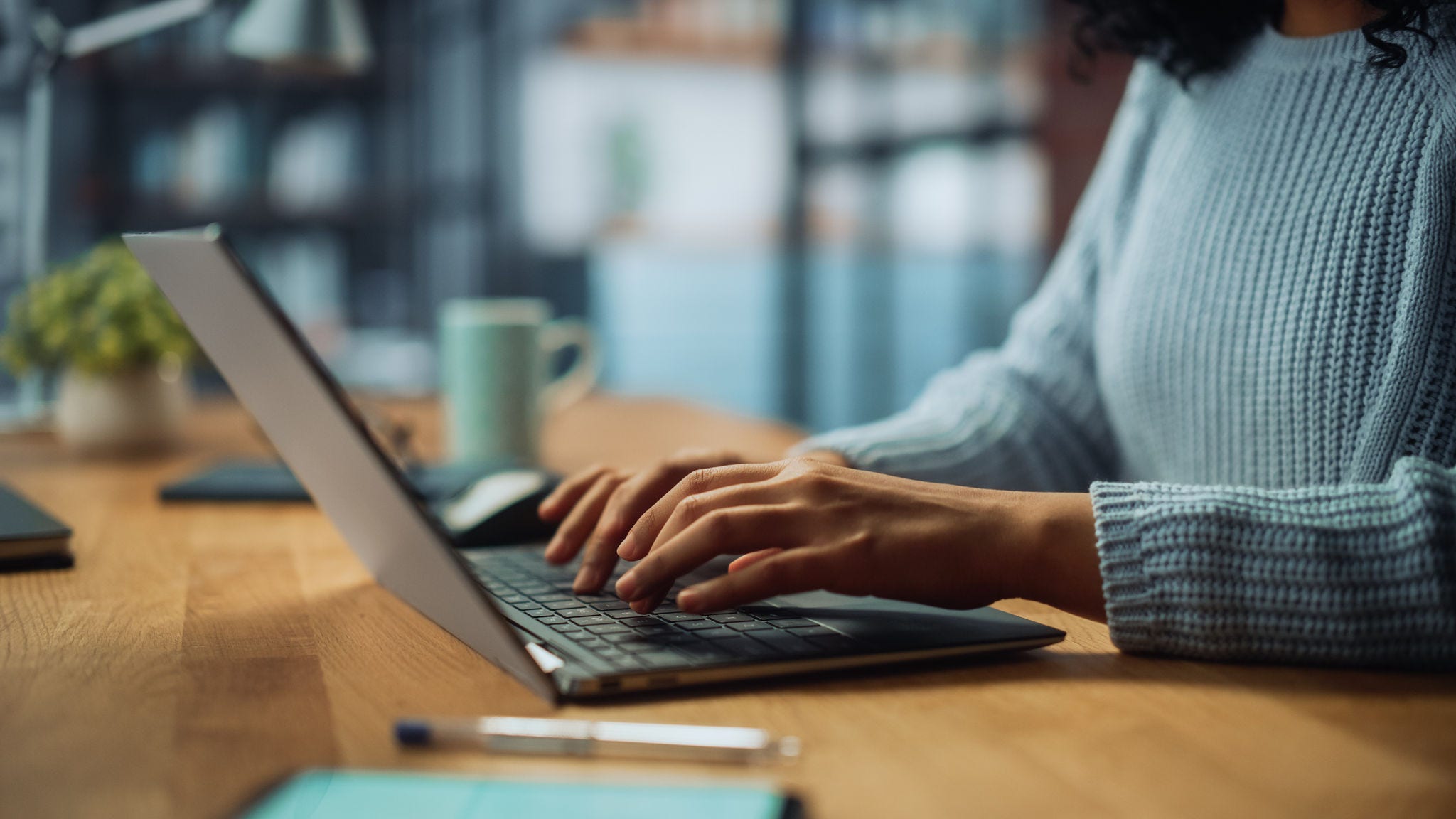 Close Up on Hands of a Female Specialist Working on Laptop Computer at Cozy Home Living Room while Sitting at a Table. Freelancer Woman Chatting Over the Internet on Social Networks.