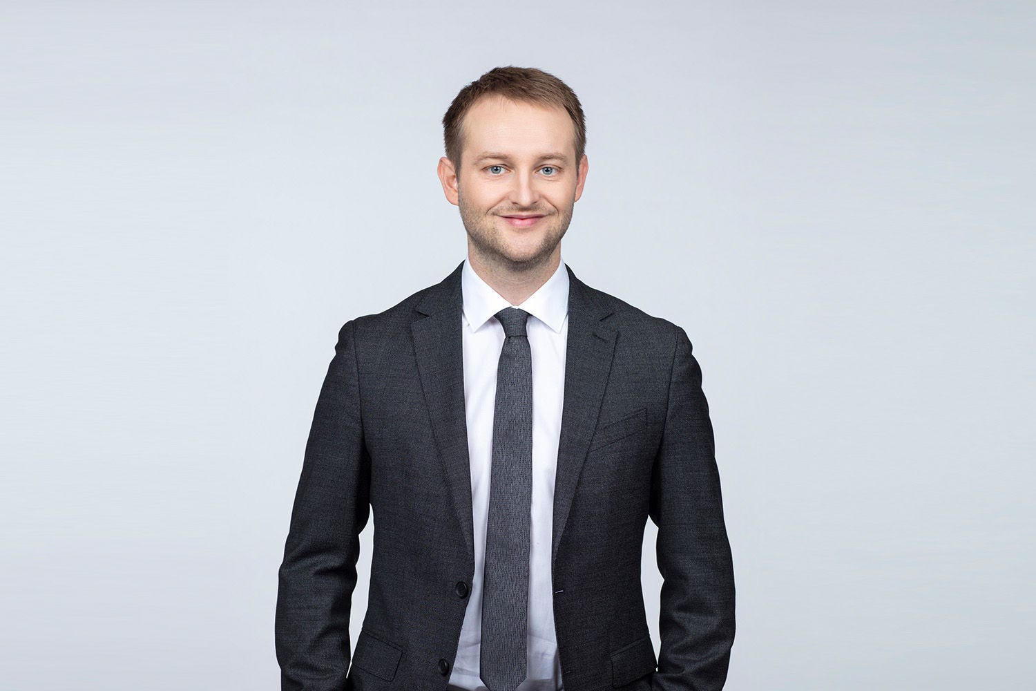 Porträt von Christian Aigner vor einer hellgrauen Wand