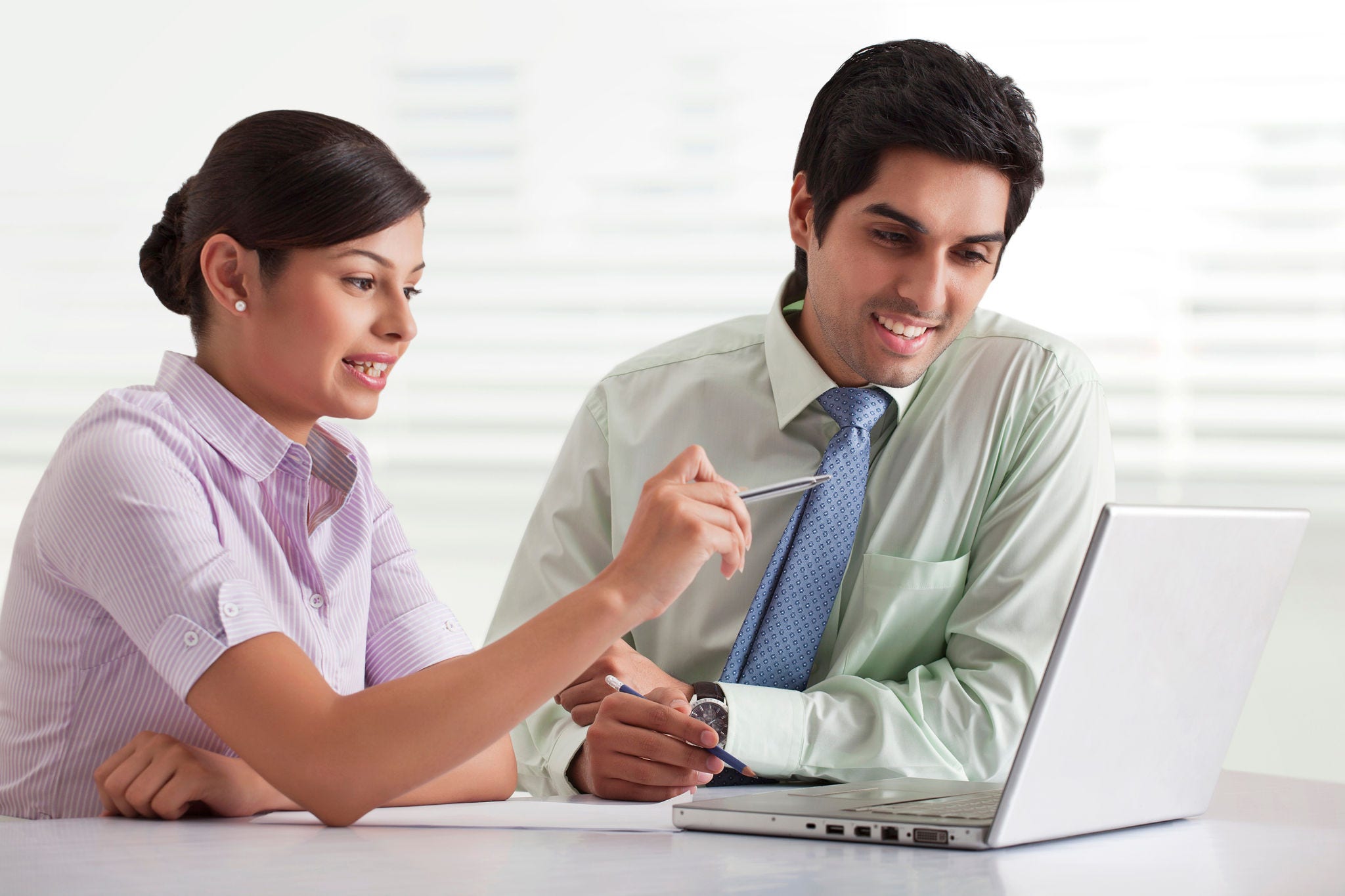 Two businesspeople preparing presentation while using laptop 