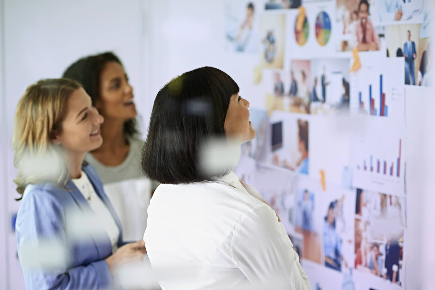 Três mulheres a visualizar dados num quadro