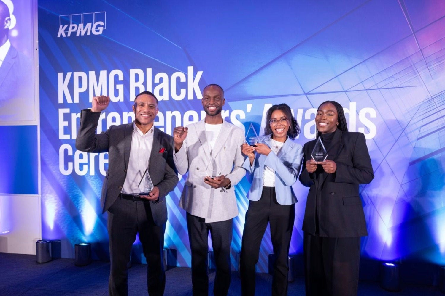 A group of four people stood in front of a KPMG Black Entrepreneurs Awards sign
