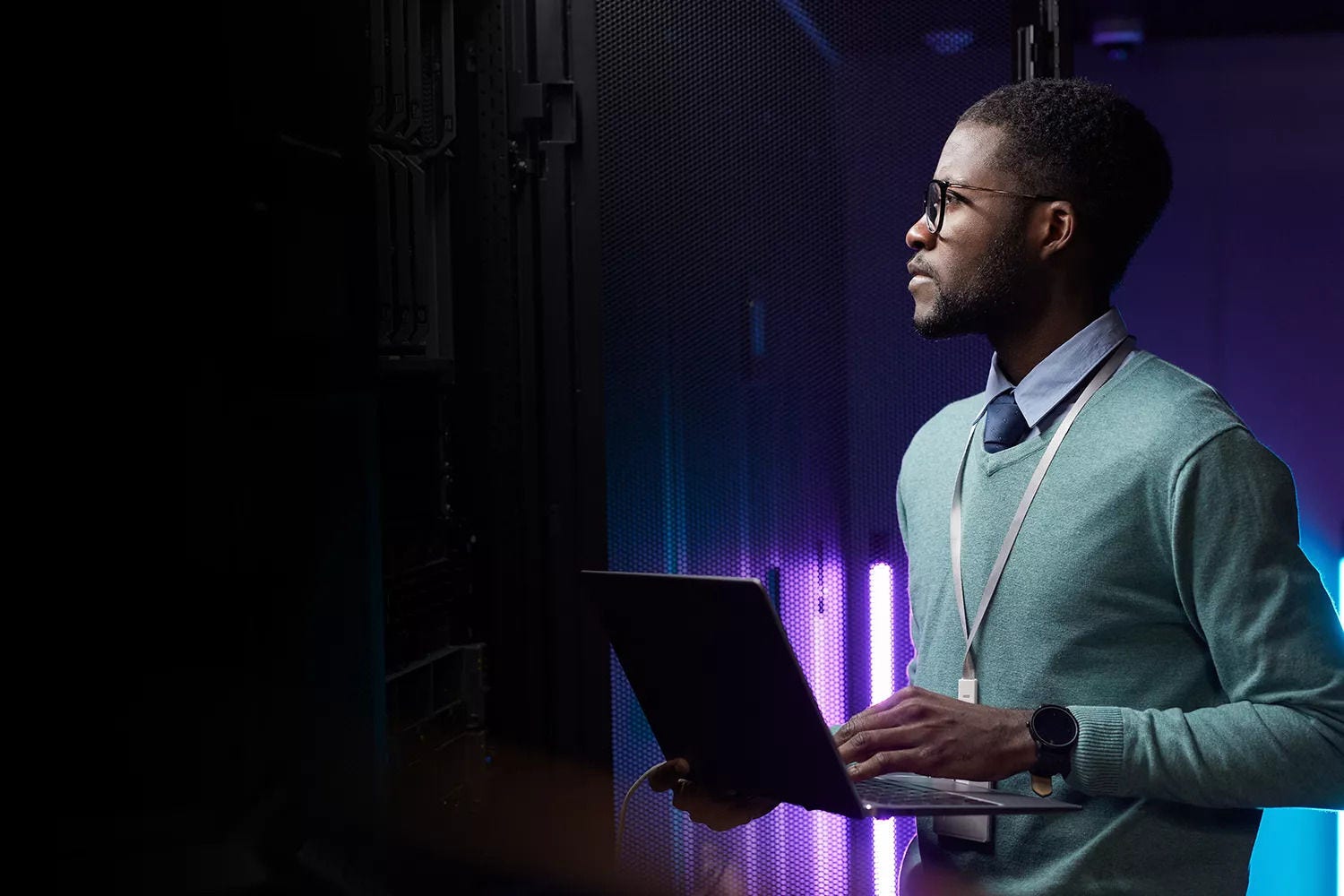 Um homem concentrado a analisar um servidor que está ligado ao seu portátil