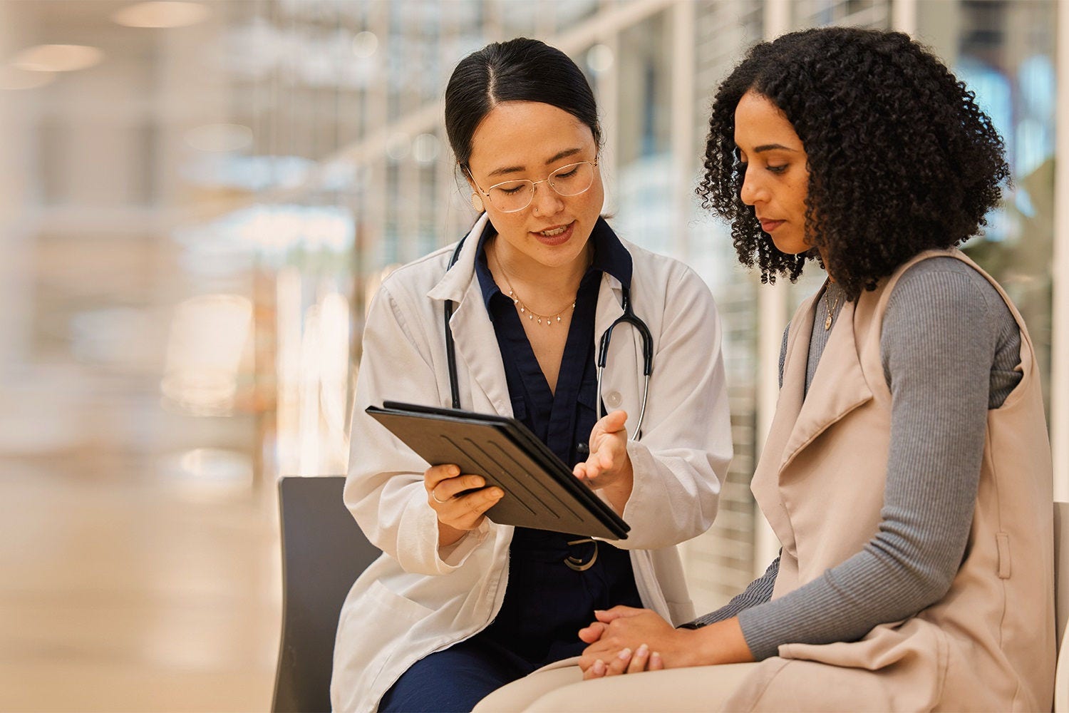 Doctor, woman patient and tablet for consulting with results, medical info and talk for healthcare with mockup space. Japanese medic, digital touchscreen or show video for surgery, wellness or advice