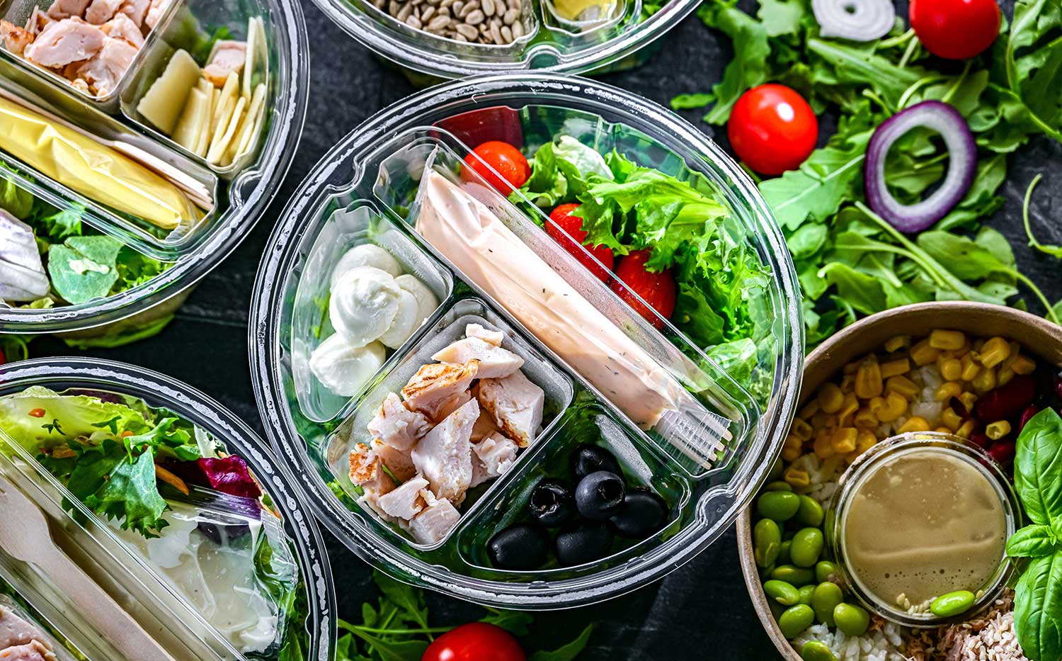 Round plastic boxes with pre-packaged vegetable salads. Convenience food