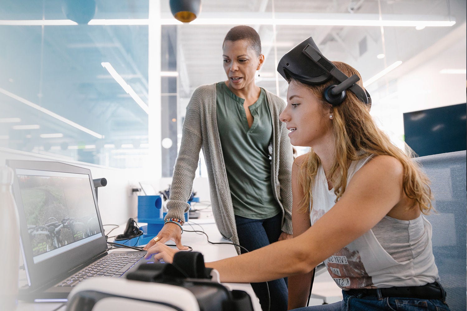 Women colleagues working on one laptop