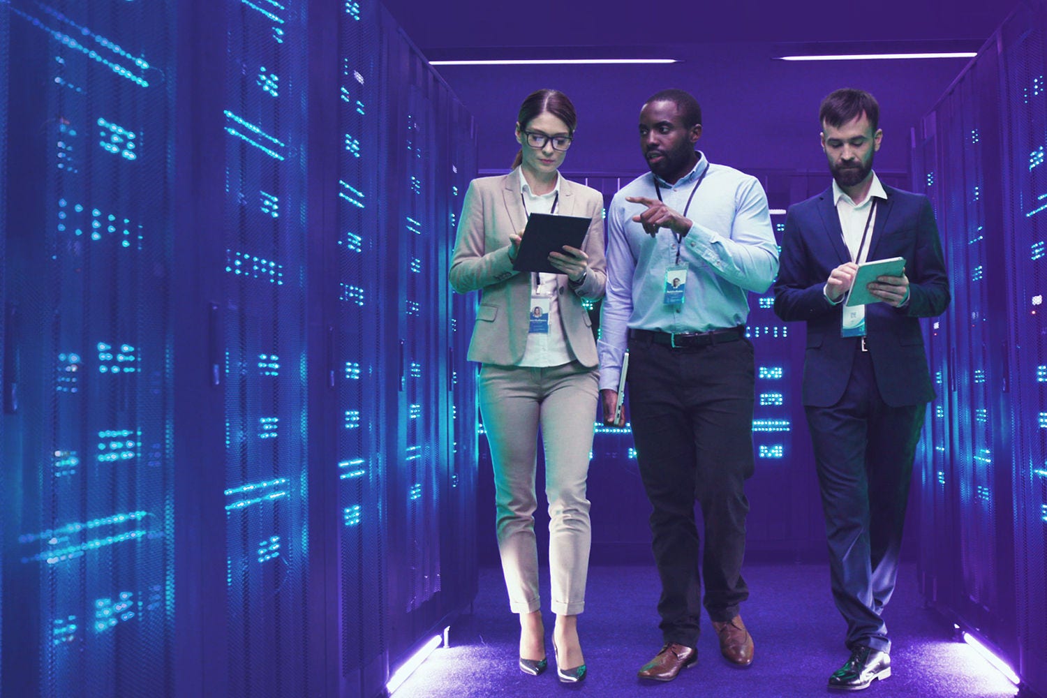 three people walking in server room and discussing something