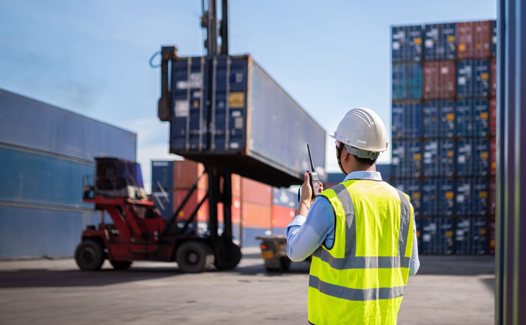 Foreman control loading Containers box from Cargo freight ship for import export  