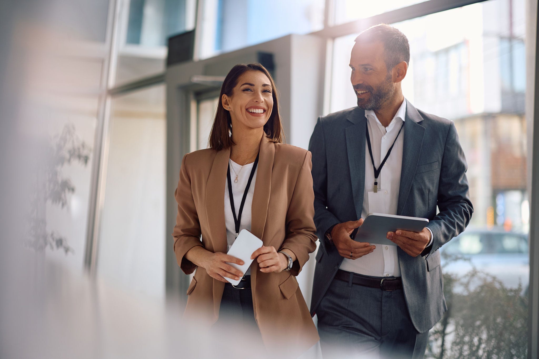 Happy business colleagues communicating while walking through an office building. Copy space.