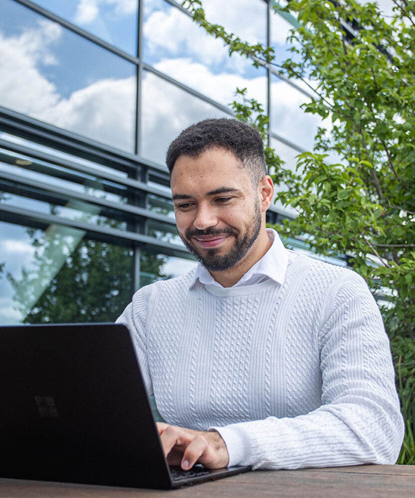 Colleague working on laptop in an outside space