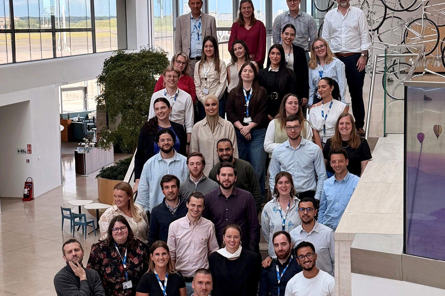 A group of people posing at the stairs of the KPMG office.