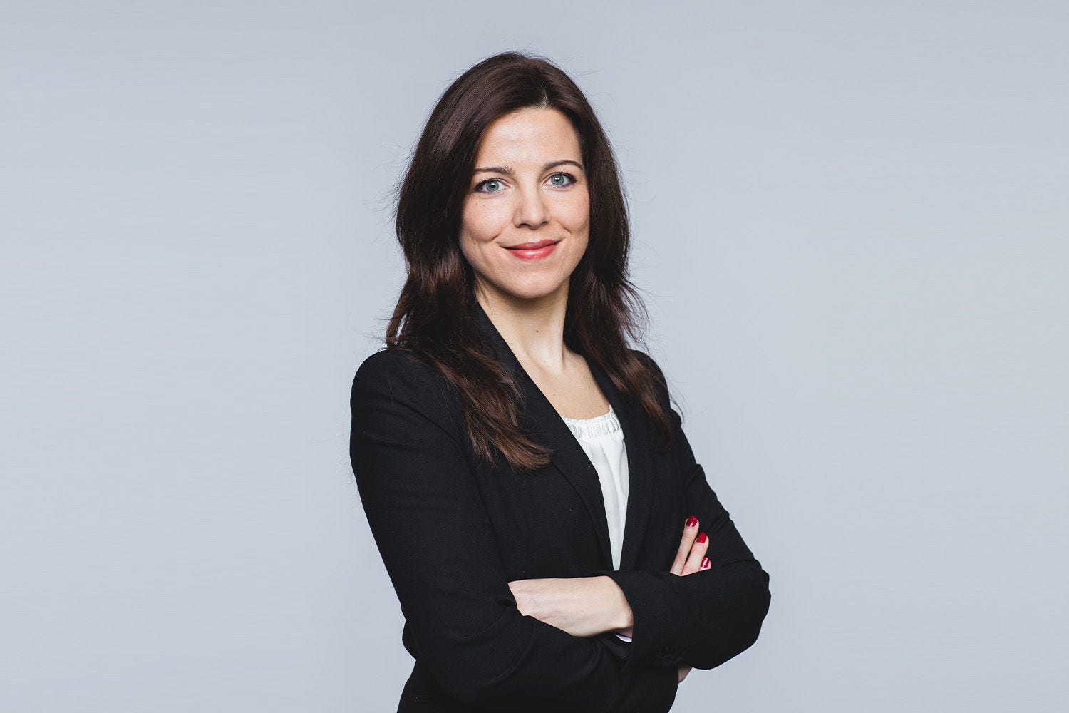 Porträt von Michaela Landauf vor einem hellgrauen Hintergrund