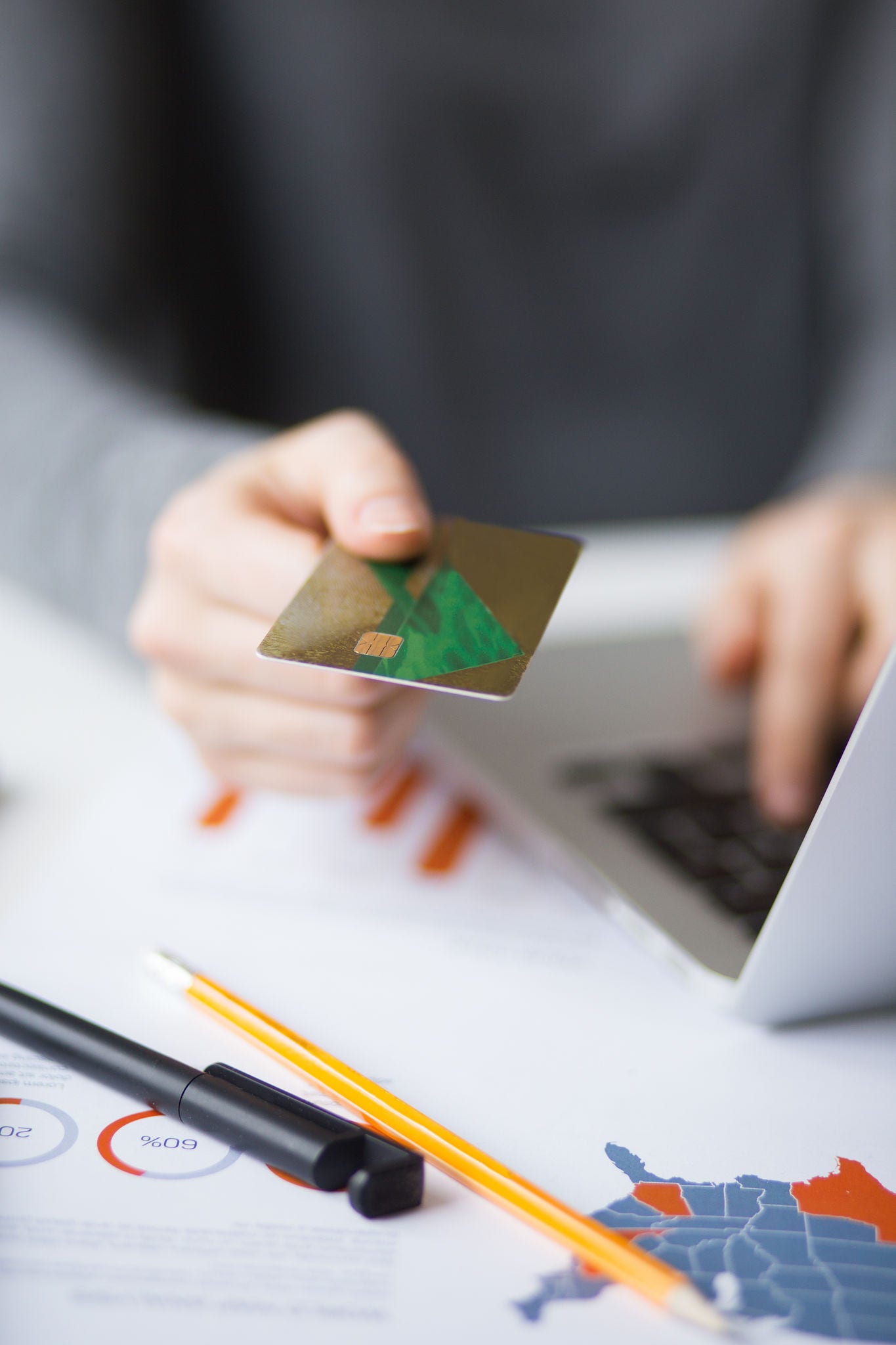Cropped view of business person working on laptop computer, holding credit card and doing online banking