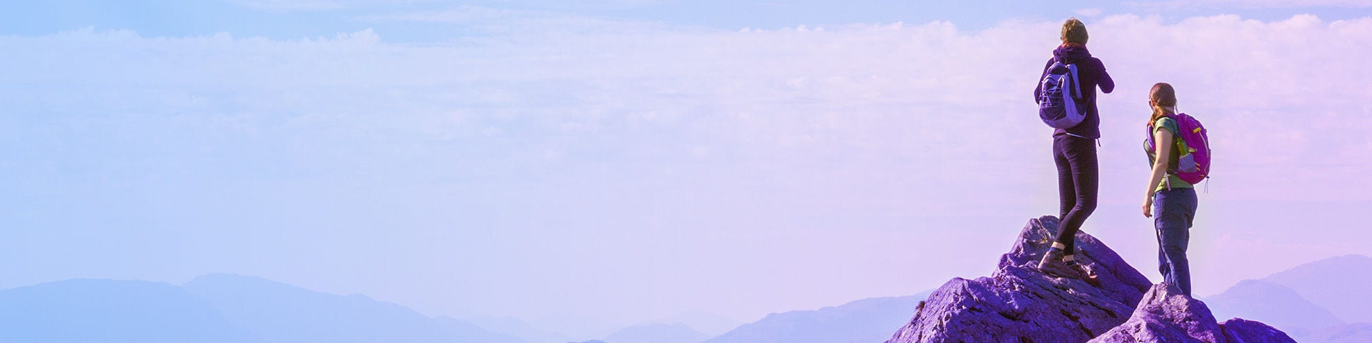 man and woman standing on cliff