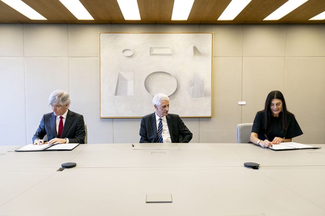 três pessoas sentadas a ler documentação