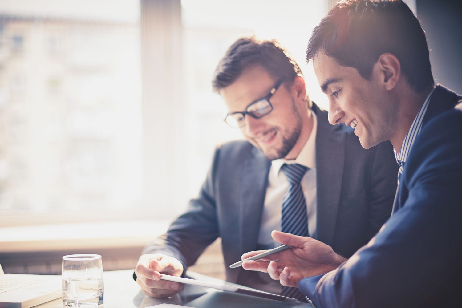 Image of two young businessmen using touchpad at meeting; Shutterstock ID 158522279; docket: KPM143004TA; PO: na; Client: KPMG; Purchaser: TAXI / KPMG