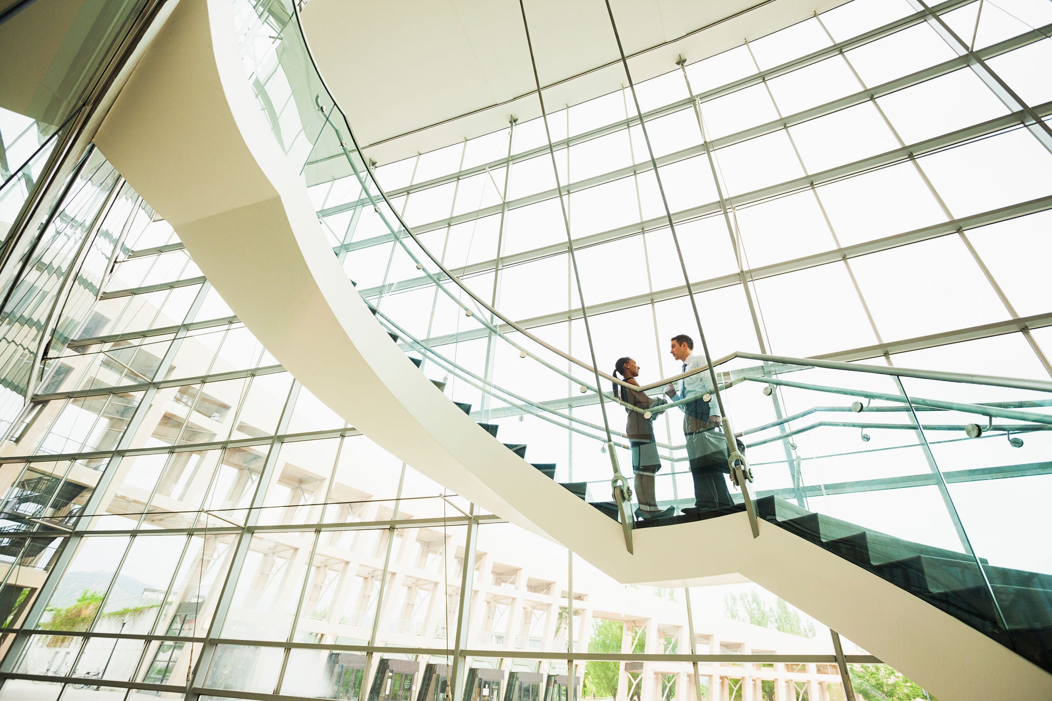 187138582 Business people talking on office staircase