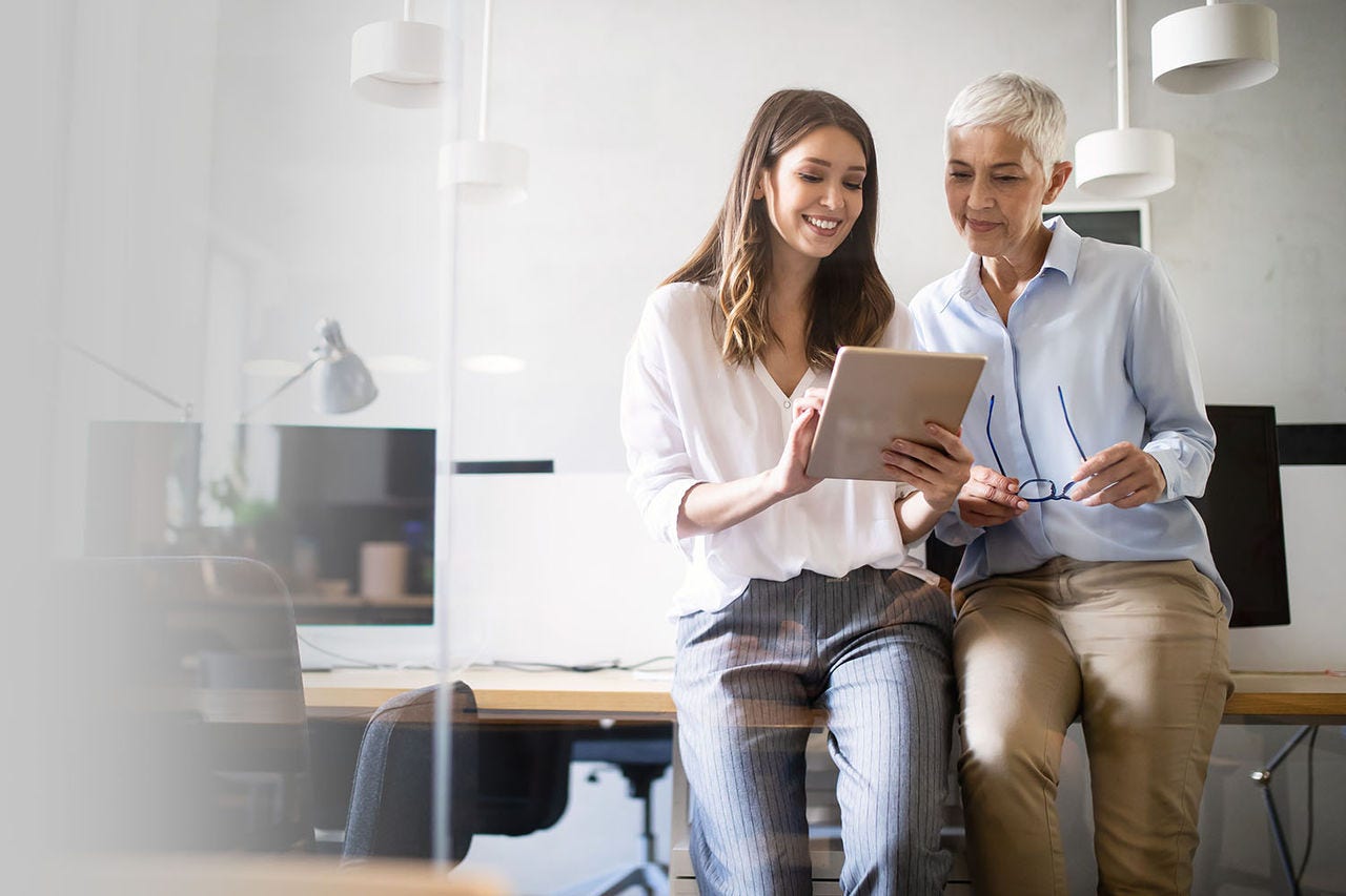 Two women in an office looking at tablet