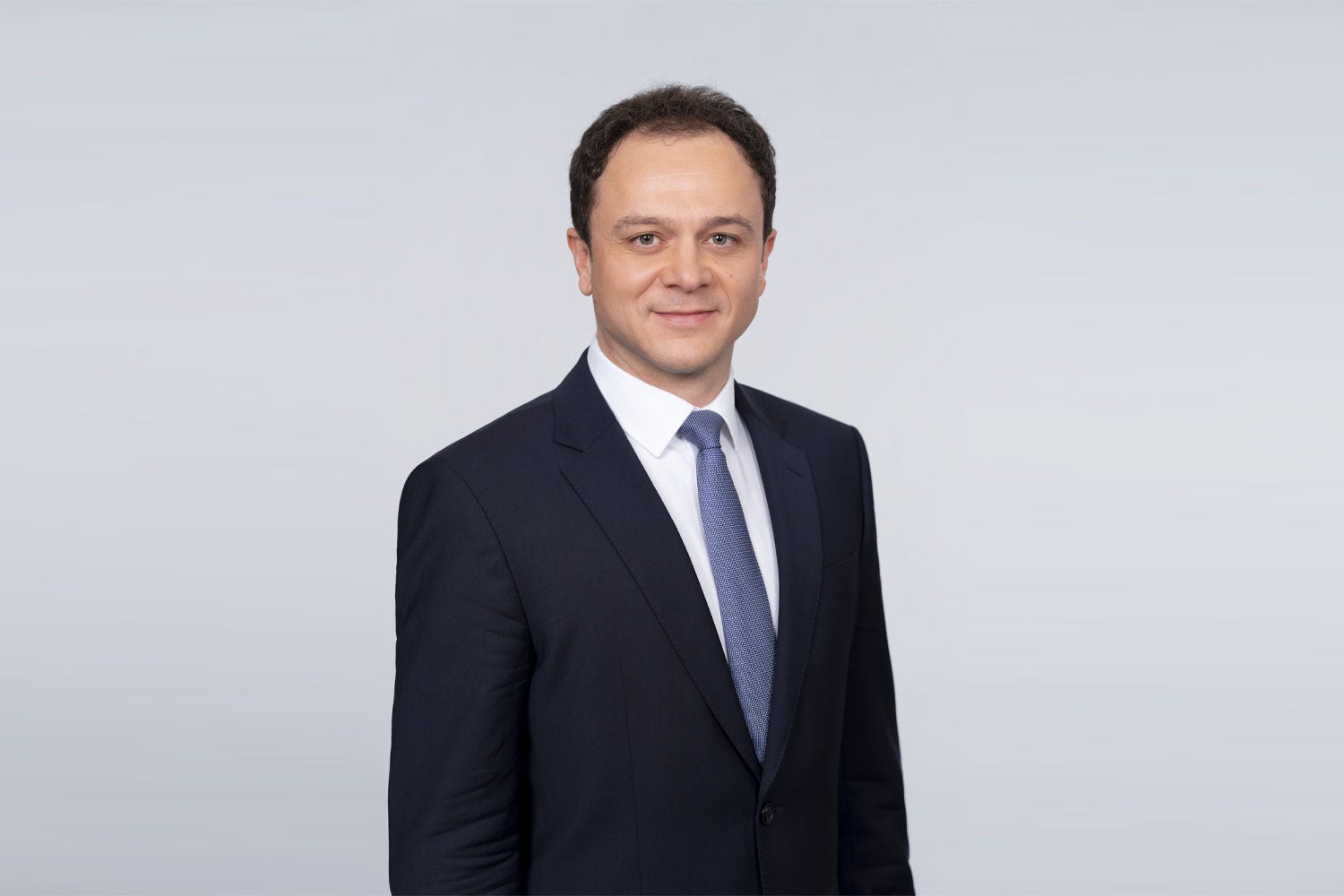 Porträt von Christoph Doleschal vor einer hellgrauen Wand