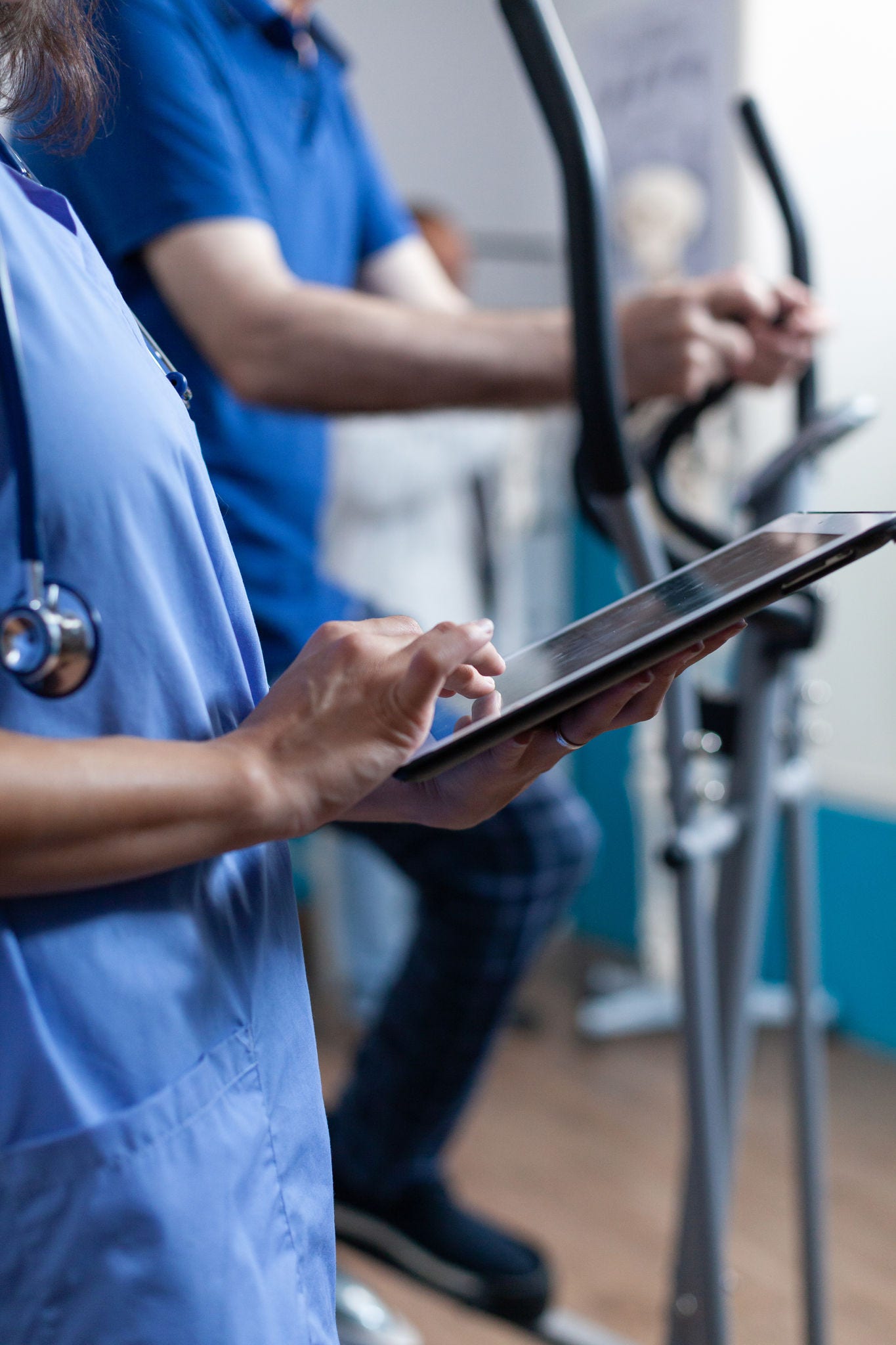Close up of medical assistant touching tablet display to help elder people with physical recovery. Nurse using gadget with touch screen for healthcare and physiotherapy for strength