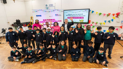 School children and teachers waving for a photograph 