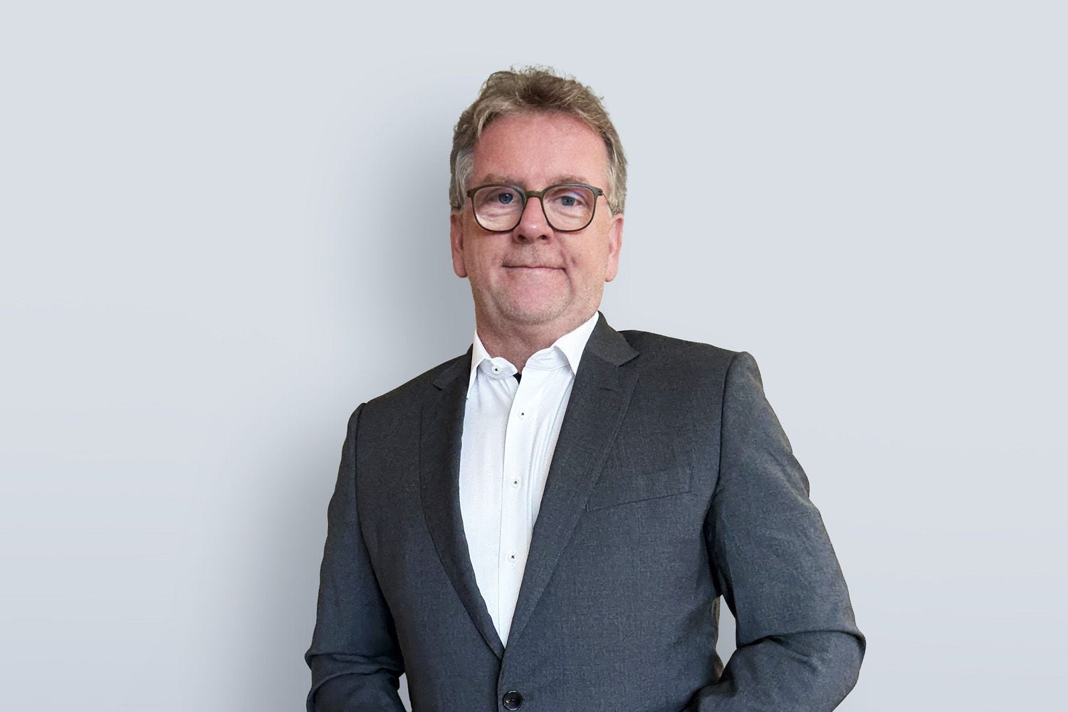 Porträg von Bernd Grubinger vor einer hellgrauen Wand