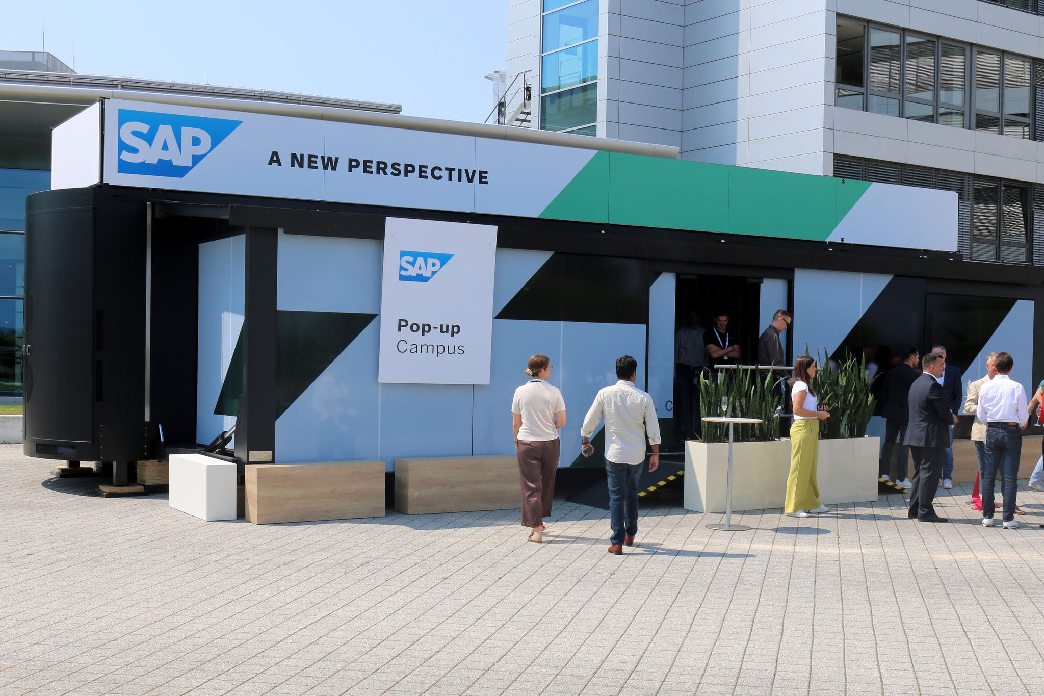 Zwei Menschen laufen auf ein Gebäude mit SAP Logo zu