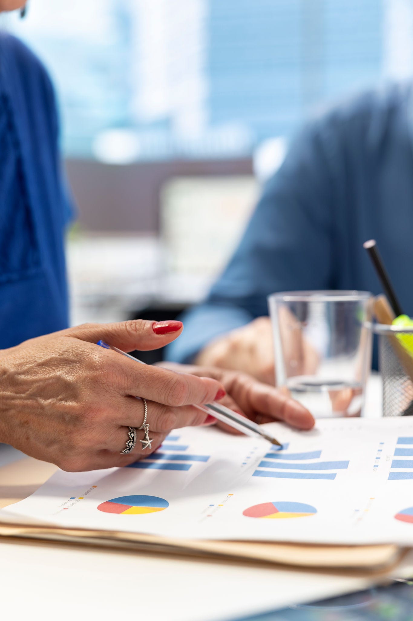 Senior people in a modern office analyzing retirement plans with a financial broker, looking into various pension options. Covering savings and family expenses with future investments.