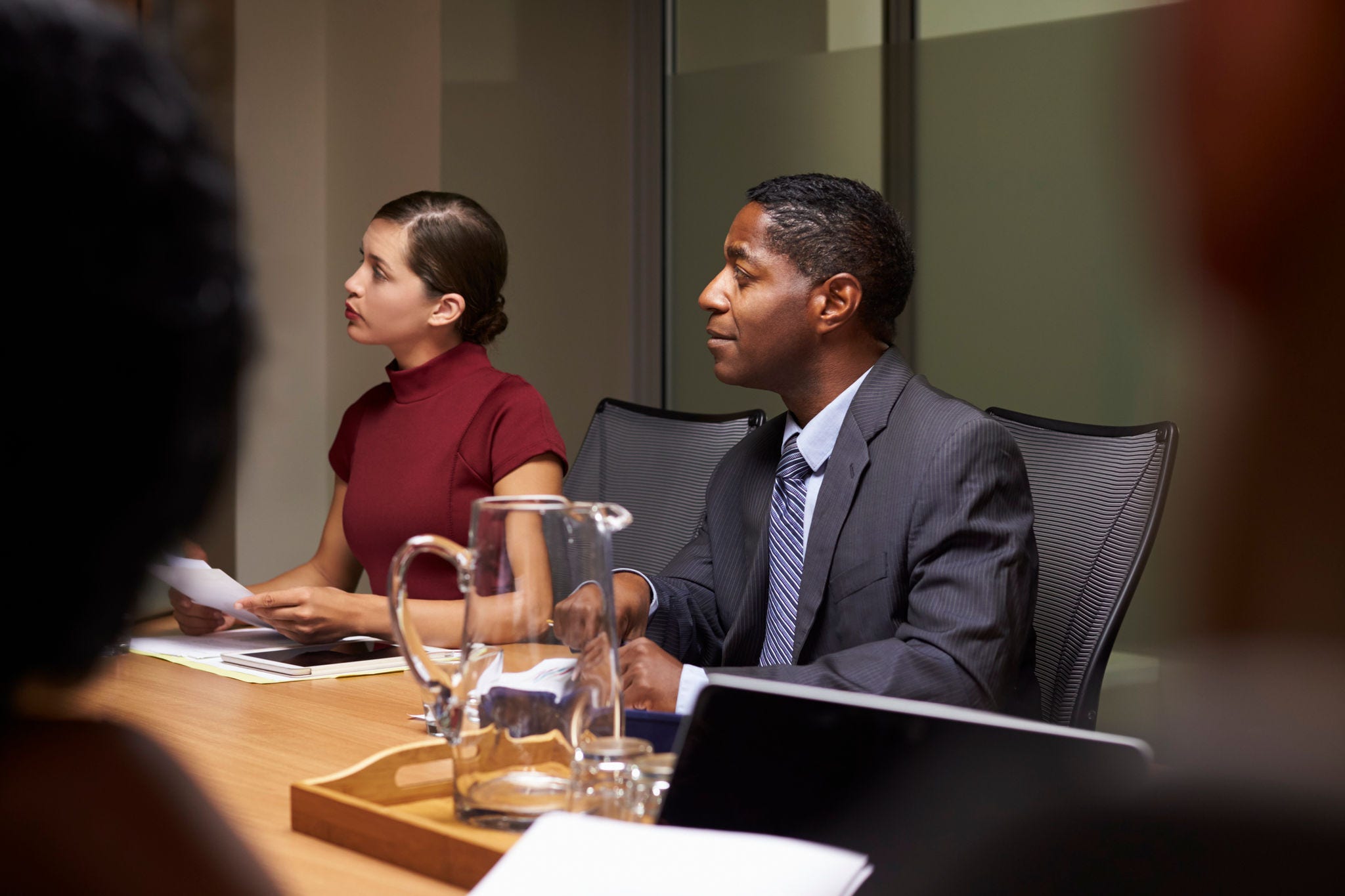 Business colleagues listening at boardroom meeting, close up
