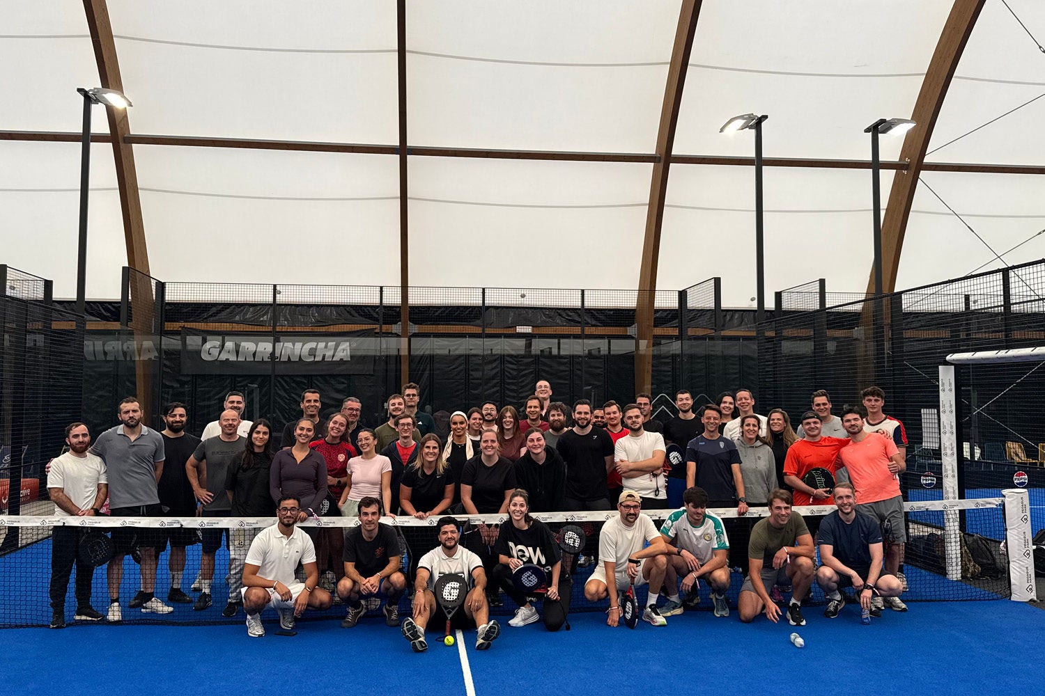 A group of people posing at a padel court