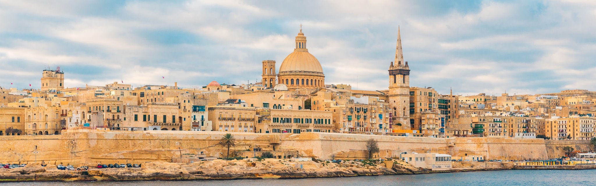 Valletta, Malta old town skyline from Sliema city on the other side of harbor during sunrise