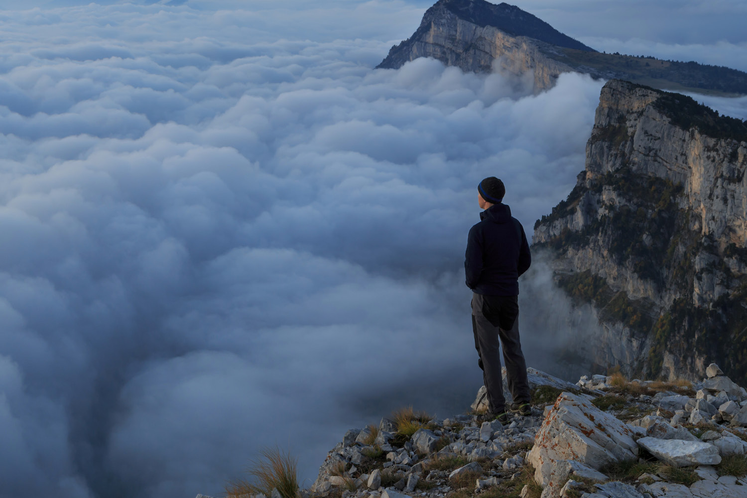 man looking over the cloud on top of a mountain