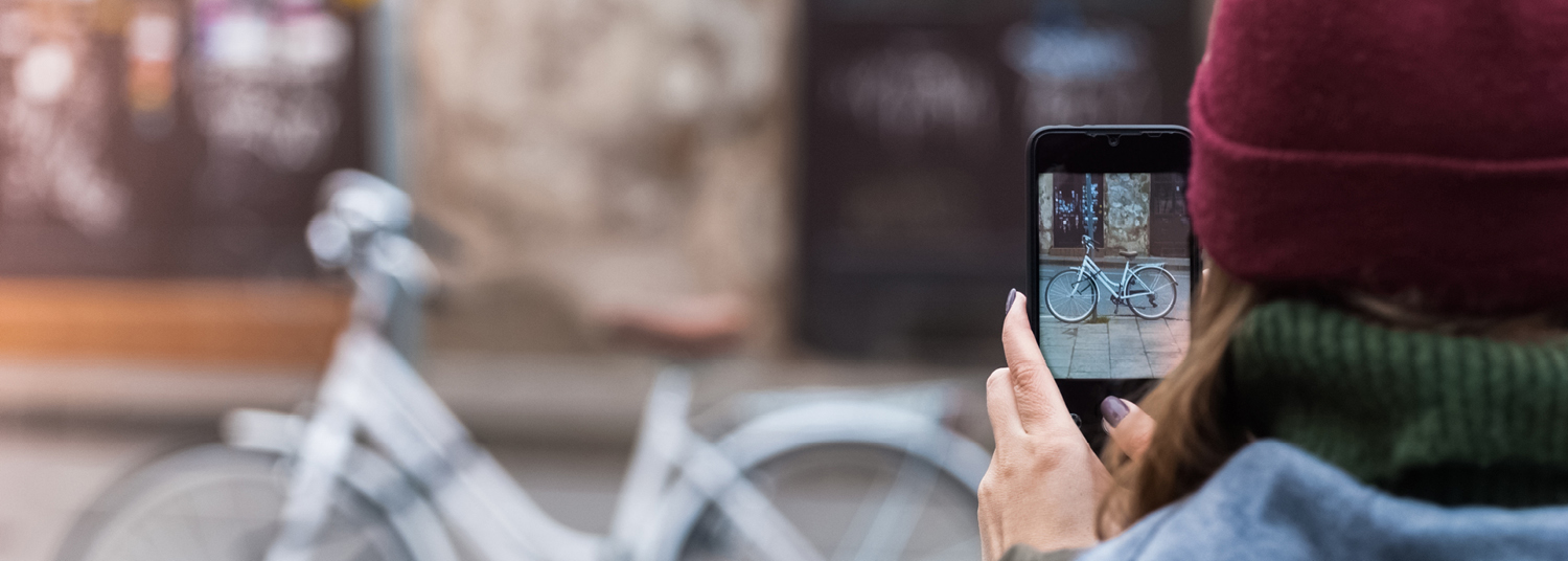 Vrouw neemt met gsm foto van fiets