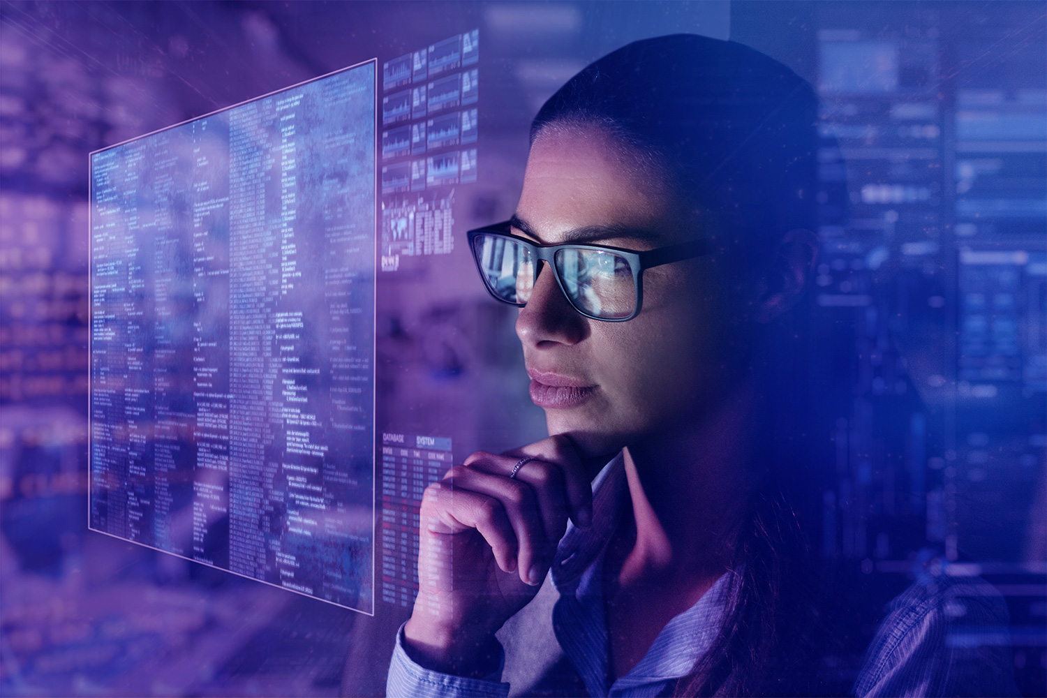 woman with glasses looking at holographic data display