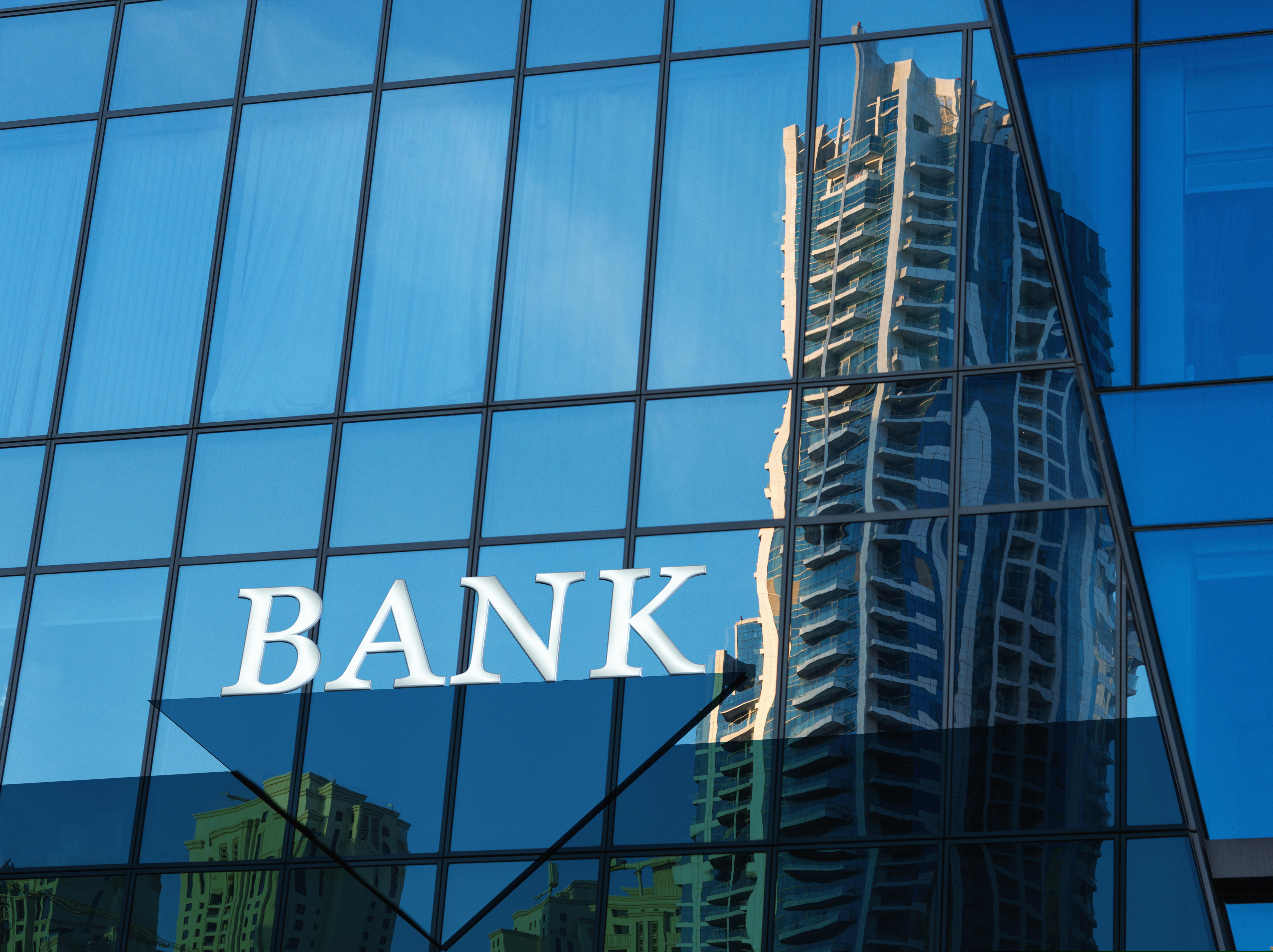 Bank sign on glass blue wall of modern building