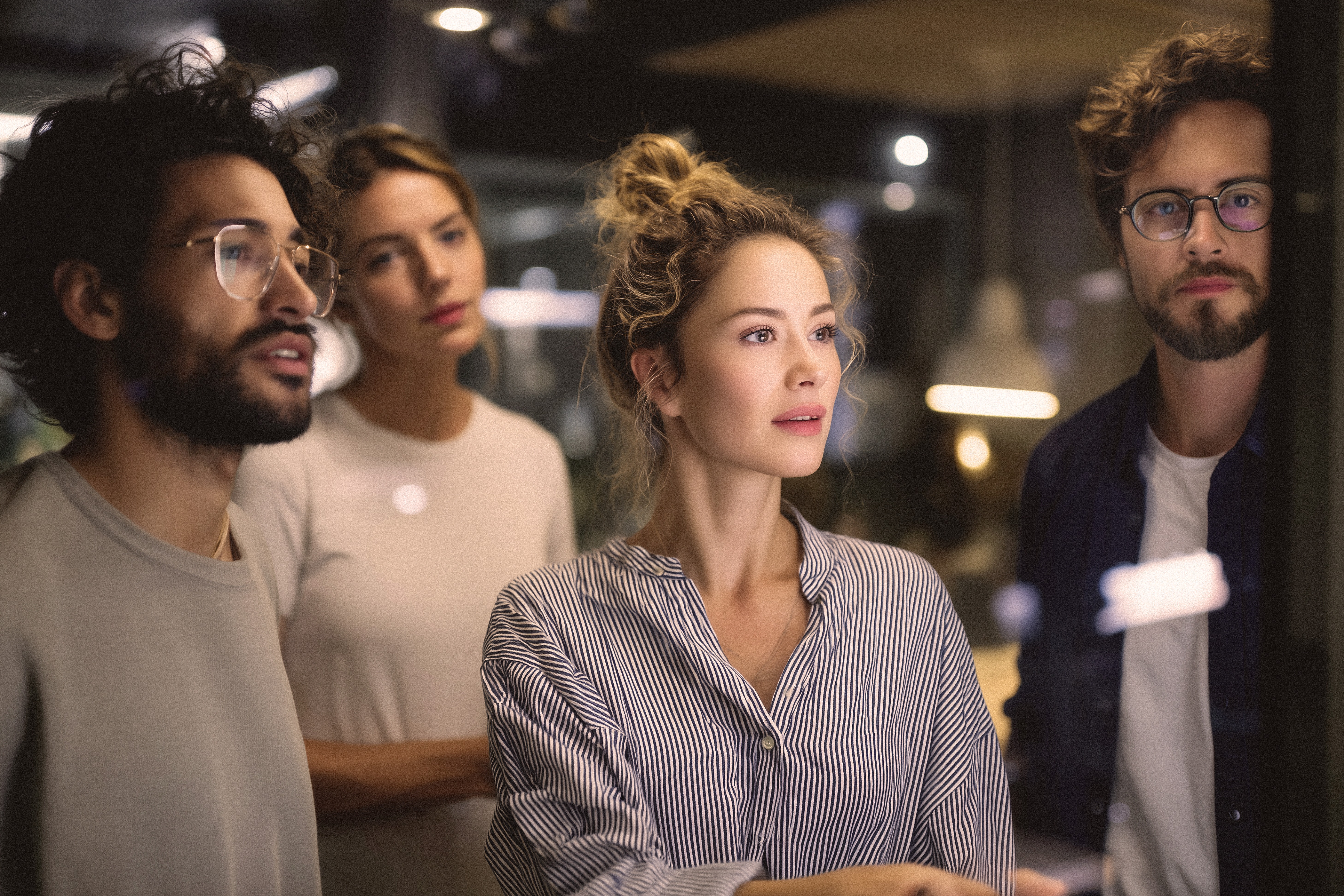 four people looking at a screen