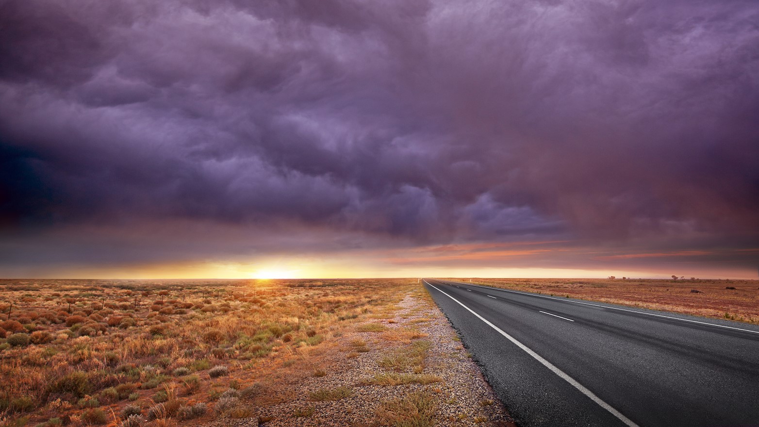 a road driving toward a dramatic with light and clouds