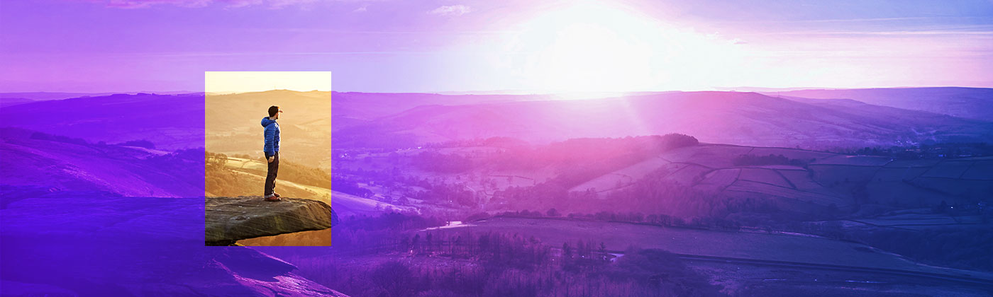 person atop mountain overlooking valley