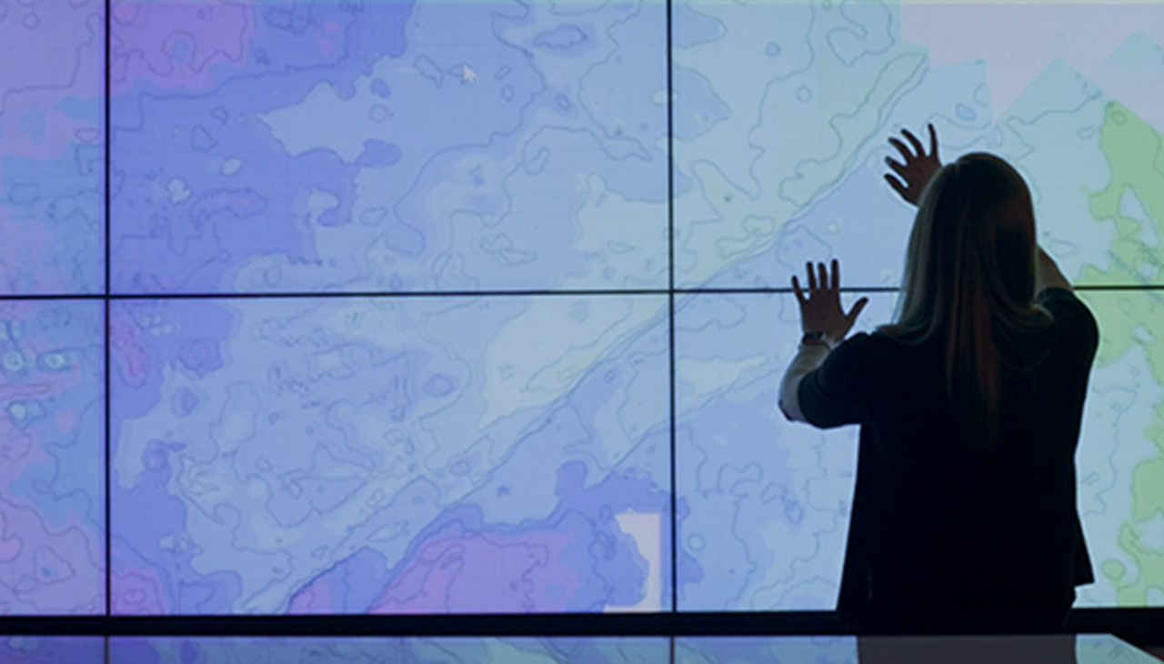 A woman interacting with a map on a digital display